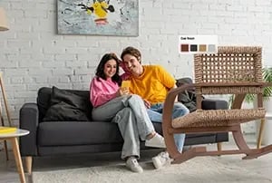 couple in living room viewing a woven chair with AR