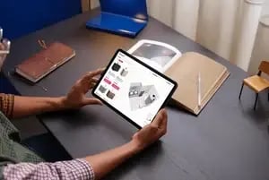 man using 3d bathroom planner on ipad at a desk
